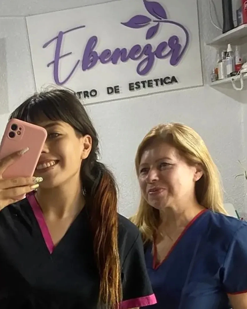 Cynthia y Estela, de Ebenezer, con ambo frente al cartel del centro
